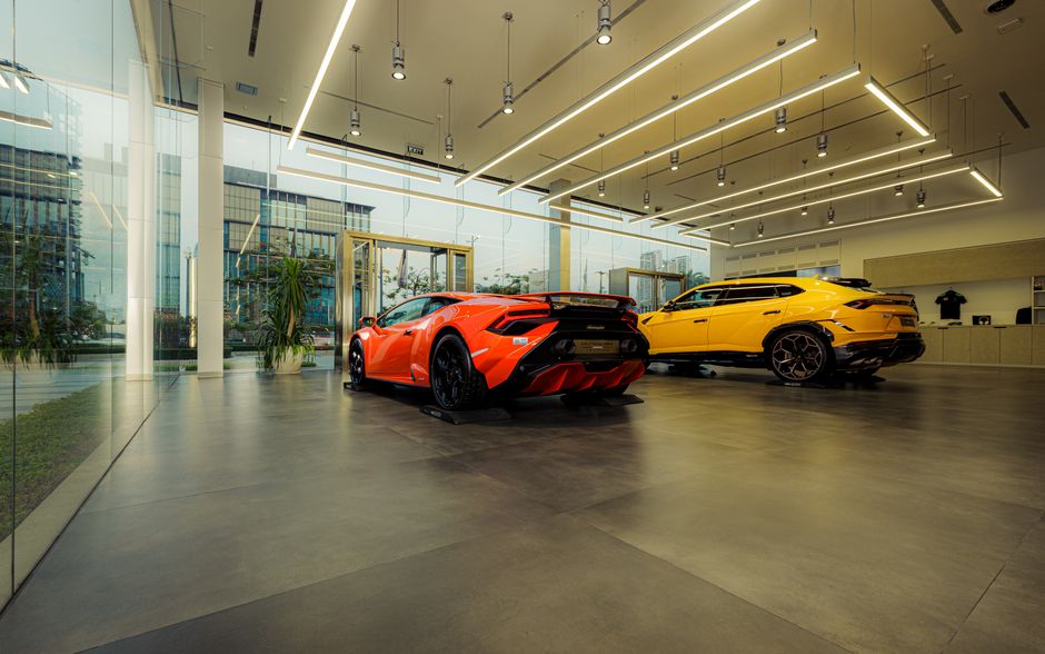 Showroom featuring luxury sports cars, Lamborghini models, with sleek design and modern architecture.